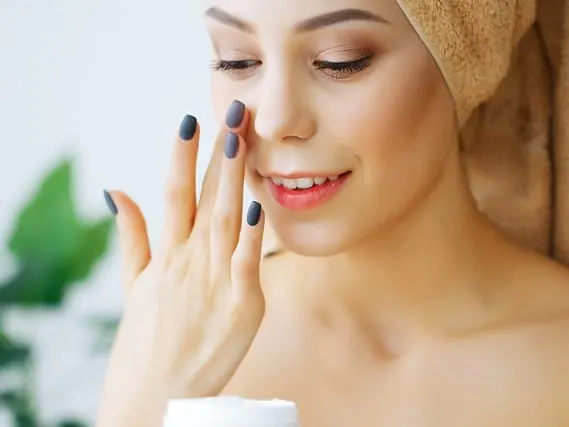 Happy Smiling Young Woman Holds Cream for Face